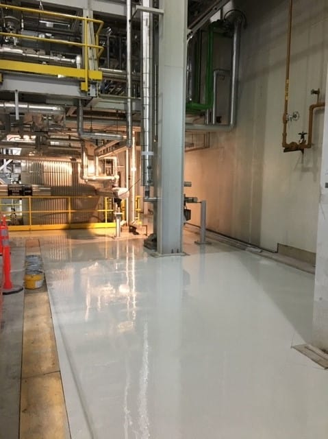 Coated floor along a turbine building wall